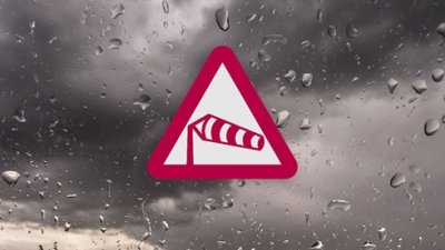 Varningstriangel med symbol för storm mot mörka moln
