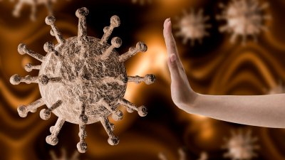 Hand som stoppar ett förstorat virus