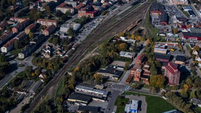 Flygbild över bangården med spår med stationen och alla spåren. Bebyggelse på båda sidor om spårområdet.