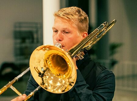 en ung man spelar trombon