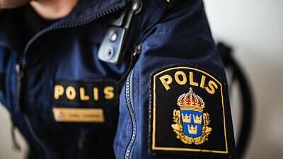 Närbild av polispersons arm med Polisens emblem