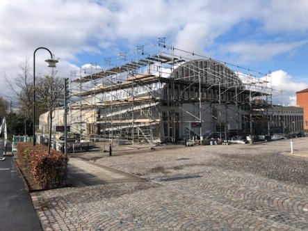 Medborgarhuset med ställningar, sett från entrésidan. Stenbeläggning i förgrunden.