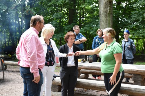 Stafettpinne i form av cykelpump lämnas över från Höörs representant till kommundirektör Eva Hellberg. Johan Andersson och Catharina Malmborg ser på. I bakgrunden tre personer från Eslövs scoutkår.